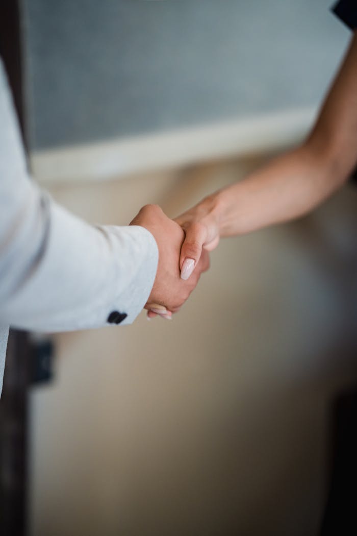 A close-up view of a handshake between two professionals, symbolizing agreement and partnership.