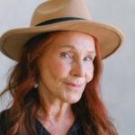 pexels photo 5257495 5257495 Charming senior woman with red hair and beige hat smiling confidently.